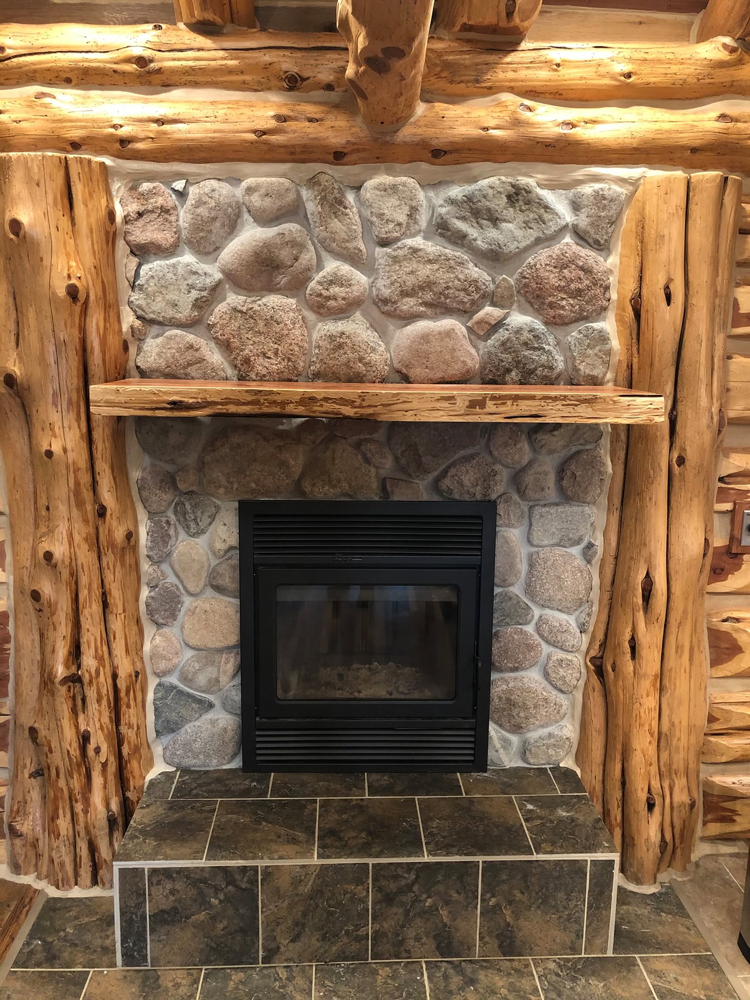 Stone fireplace with hand-peeled cedar mantel