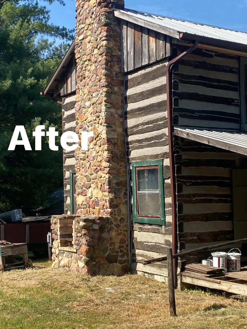 Restored log building with stone chimney, after restoration