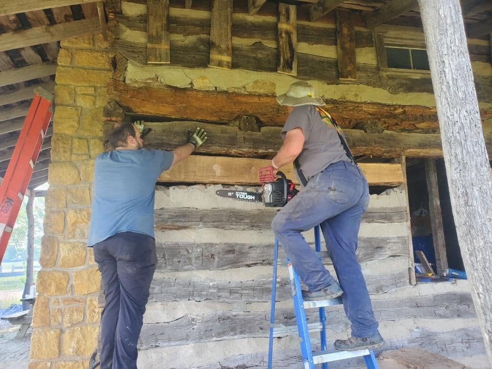 Crew installing a matched replacement log in a historic wall