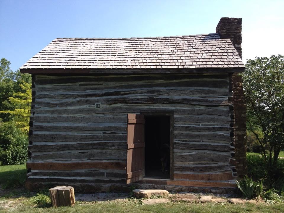 Restored historic log cabin with stone chimney